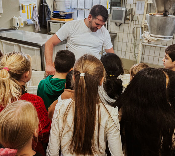 Die Kinder hören aufmerksam bei der Backstubenführung zu